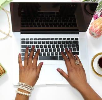 a woman's hands typing on a laptop computer