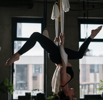 Girl hanging upside down on material