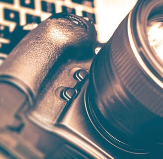 A modern DSLR camera paired with an interchangeable lens, arranged on a sleek surface to highlight learning photography