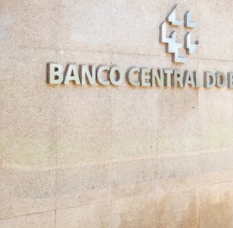 Fachada do Banco Central do Brasil, com logotipo metálico e parede de pedra clara, em perspectiva