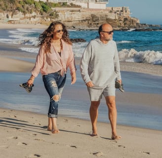 Pareja de jubildados caminando por la Playa al migrar a España