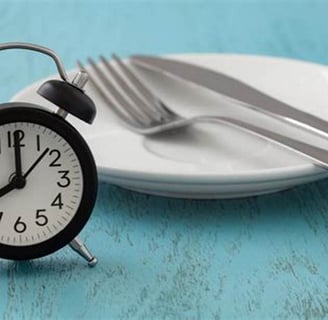 a clock on a plate with fork and fork