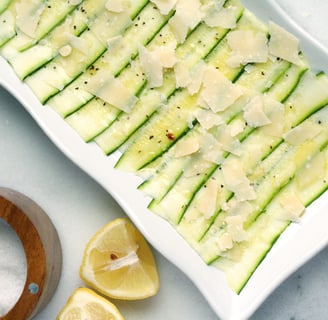 Un plato rectangular blanco con un carpaccio de calabacín