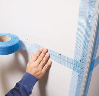 a person holding a tape tape and tape tape on a wall