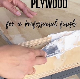 a person painting a wood table with a paintbrush