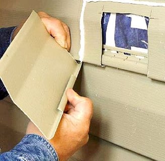 a man is putting a piece of paper in a hole in the wall