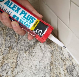 a person holding a tube of glue and a tube of glue