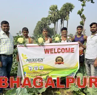 a group of men standing in a field of NXG Tejas Cauliflower with a banner that says welcome  Nexgen