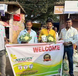 a group of men standing in front of a banner board of NEXGEN SEEDS CAULIFLOWER 