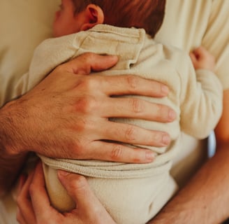 le père qui tient son nouveau né dans les bras