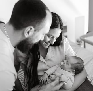 Une femme et son homme qui tiennent leur nouveau né dans les bras