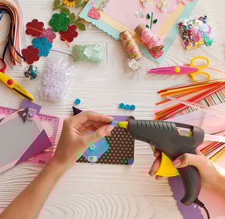 a person is using a glue gun to make a craft