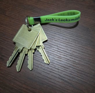 A Jack’s Locksmith green key ring with golden keys attached representing a master key lock system 