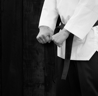 a man in a white shirt and black belt belt