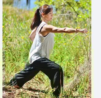a woman in a white tank top and black pants