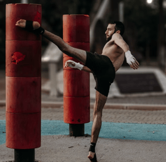 a man kicking a kickboxe in a gym