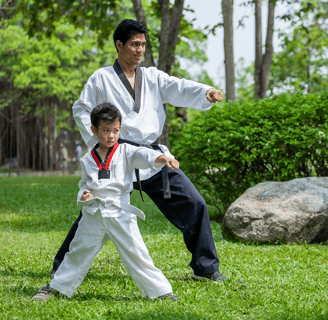 a man and a boy are practicing karate moves