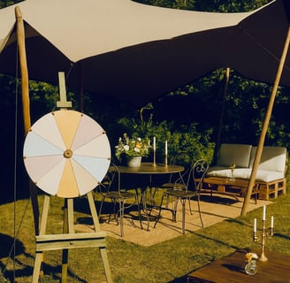 Roue de la chance vintage sous tente, coin jeu et salon en plein air décoré dans un style guinguette