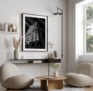 a living room with a couch and chairs and black and white architecture  hanging on the wall