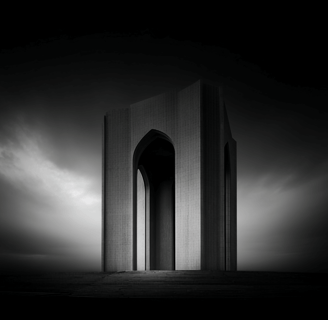 Modern tower with arches under moody sky.