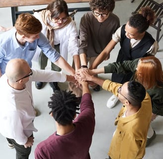 a group of people holding hands in a circle at AA meeting
