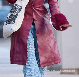 a woman in a red leather jacket and jeans