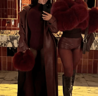 two women in leather jackets and boots standing in front of a mirror