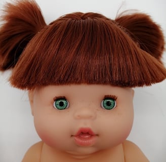 a Minikane baby doll with red hair and green eyes