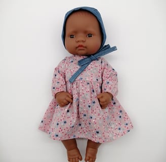 Small Miniland doll in handmade pink dress and denim bonnet