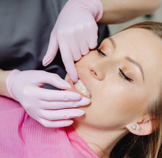 a woman is getting her teeth brushed with a dental mirror