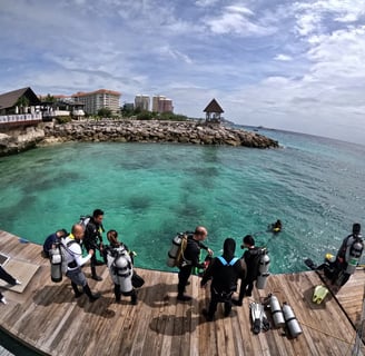 Divers in the jetty port before jumping down into the clear waters of Shangrila