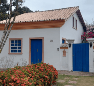 Imagem de uma casa branca com portas azuis