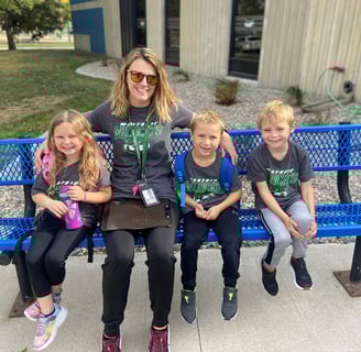 a woman sitting on a bench with three children