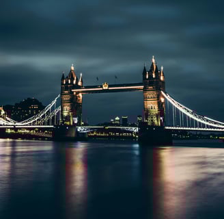 Illuminated Tower Bridge reflecting on the River Thames at night in London