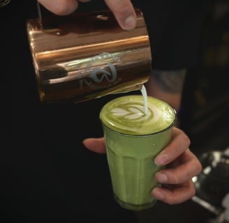 pouring a tulip on a matcha latte