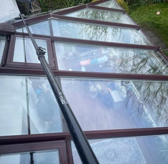 outdoor cleaning services Fife - extendable brush cleaning a glass conservatory roof