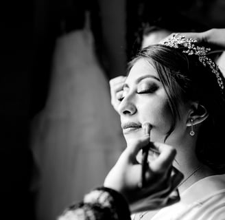 a woman getting her makeup done by a professional makeup artist