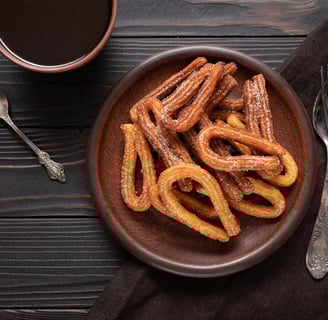 a bowl of churrons with a cup of coffee