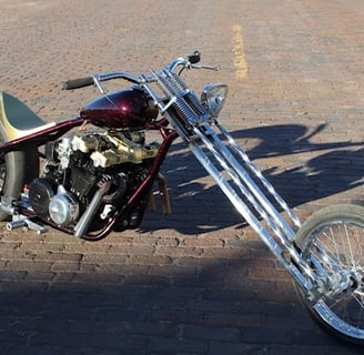 Custom motorcycle parked on brick road