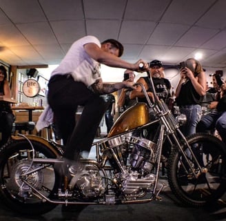 man kickstarting his motorcycle in a bar crowded with people