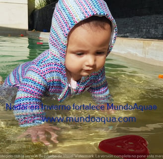 a baby in a pool with a frisbee in the water