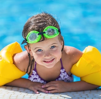 a young girl in a bikinisuit is laying on a swimming pool