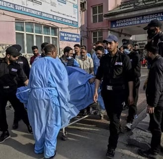 a group of people standing around a man in a blue blanket