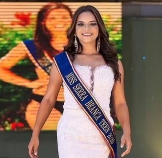 a woman in a white dress and a blue sash sash