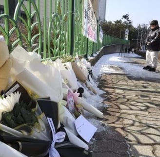 a teddy bear is placed on a fenced in area