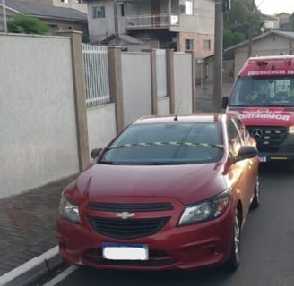 a red car is parked on the side of a street