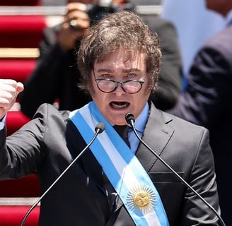 a man in a suit and tie is holding a microphone