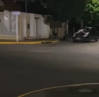 a car driving down a street with a car in the background