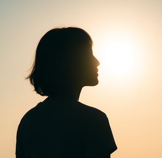 Imagen de perfil de una mujer.El sol está atrás de ella, no se nota su cara pero parece en reflexión