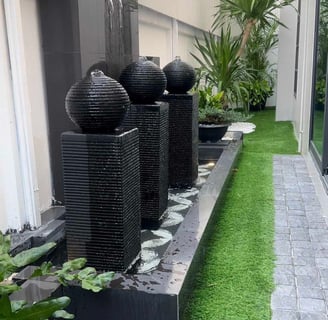 a garden with a grass lawn and a fountain